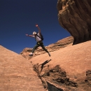 sejour-montagne-escalade-jordanie-randonneur-sautant-par-dessus-un-siq-etroit-mais-profond_mv